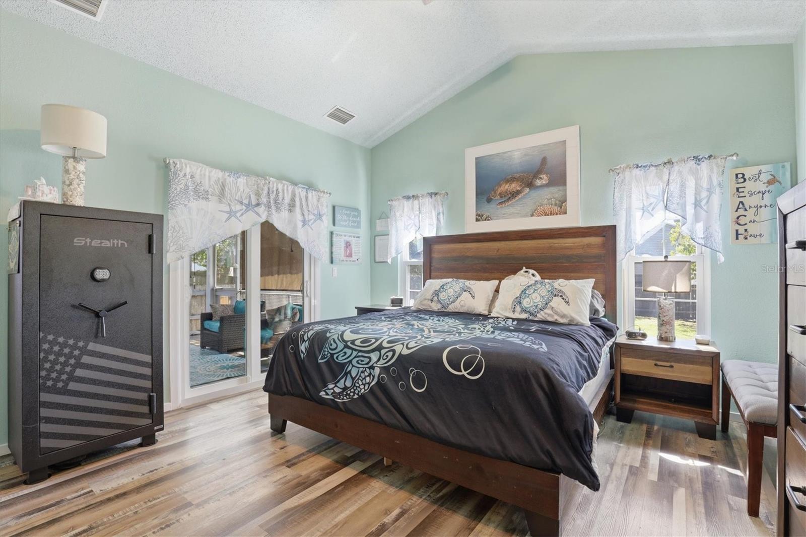 Primary suite with en suite bathroom, two closets, and direct access to the back porch through sliding glass doors.