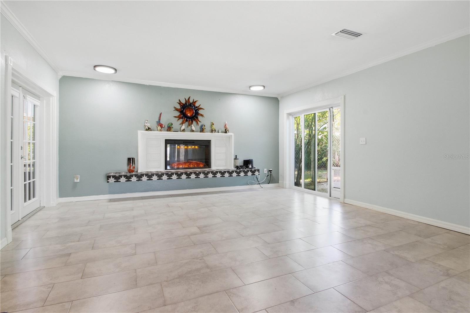 From the front entrance you see the huge family room with one of two electric fireplaces in the home. Sliding doors to the right and french doors to the left.