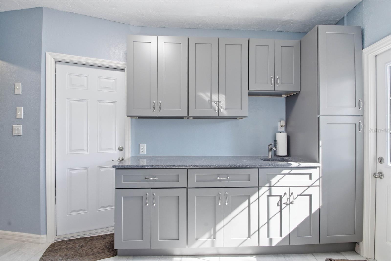 Just off the living room area is the mud room with it's own outside entrance. Also included is a wet bar perfect for entertaining and with plenty of storage. The door to the left leads to the garage.