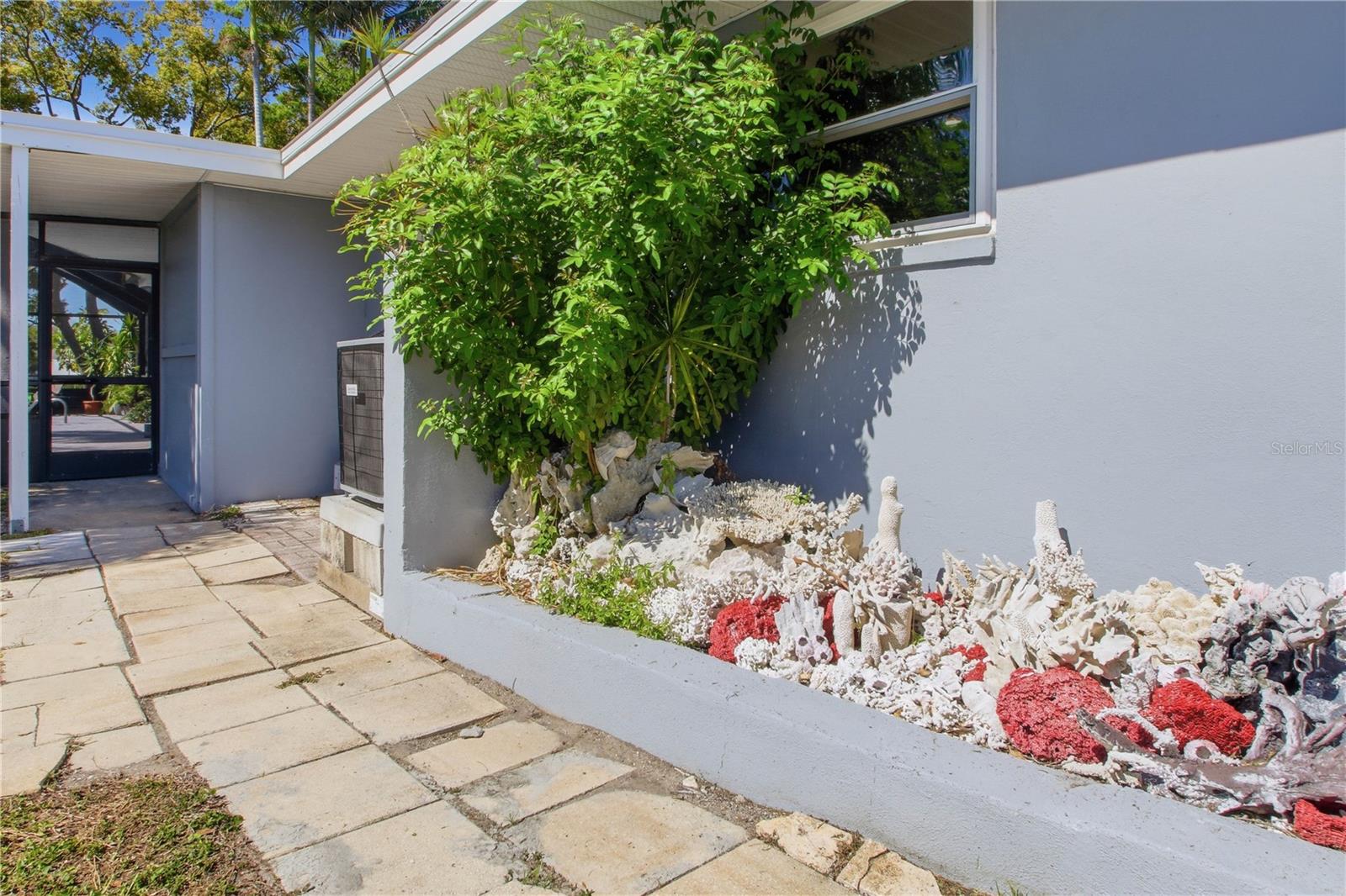 Lets take a walk outside now. This path is located to the left of the garage and leads to mudroom and well as the pool area, just a bit further down.