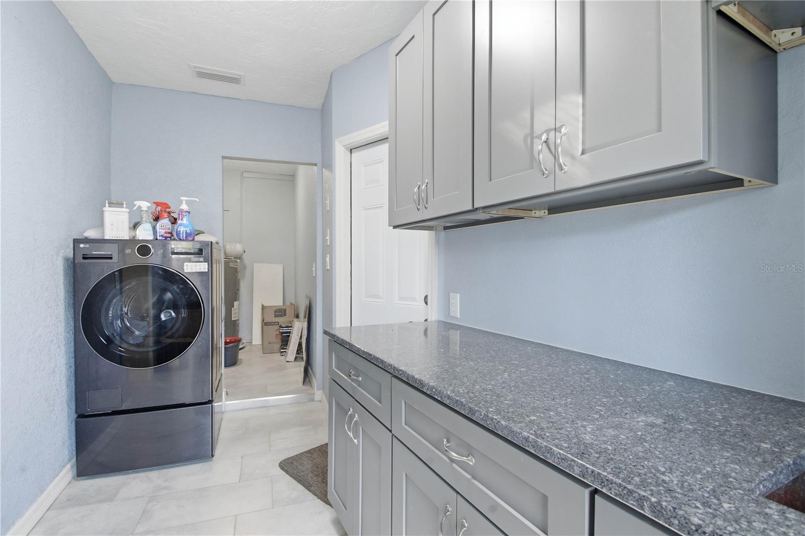 This is also where the laundry area is along with more extra storage in the back room. This wishing machine is both a washer AND a dryer and remains with the home.