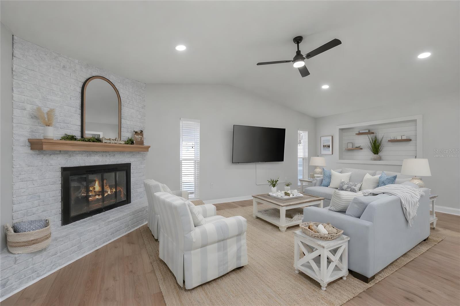 Virtually Staged -Vaulted ceilings and a wood-burning fireplace anchor the living space.