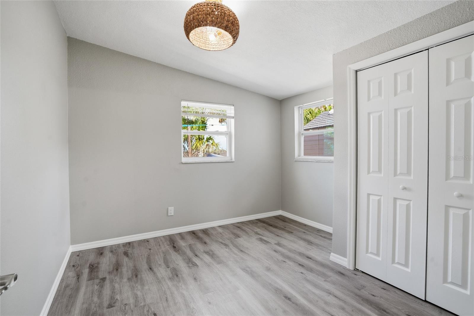 spacious back bedroom with desk alcove and matching coastal ceiling fan light