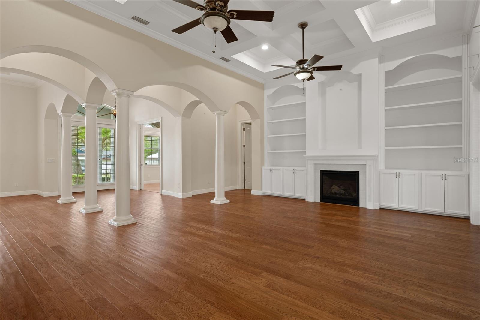 Living Room with Coffered Ceiling and Custom Built-In Cabinetry with Crown Molding