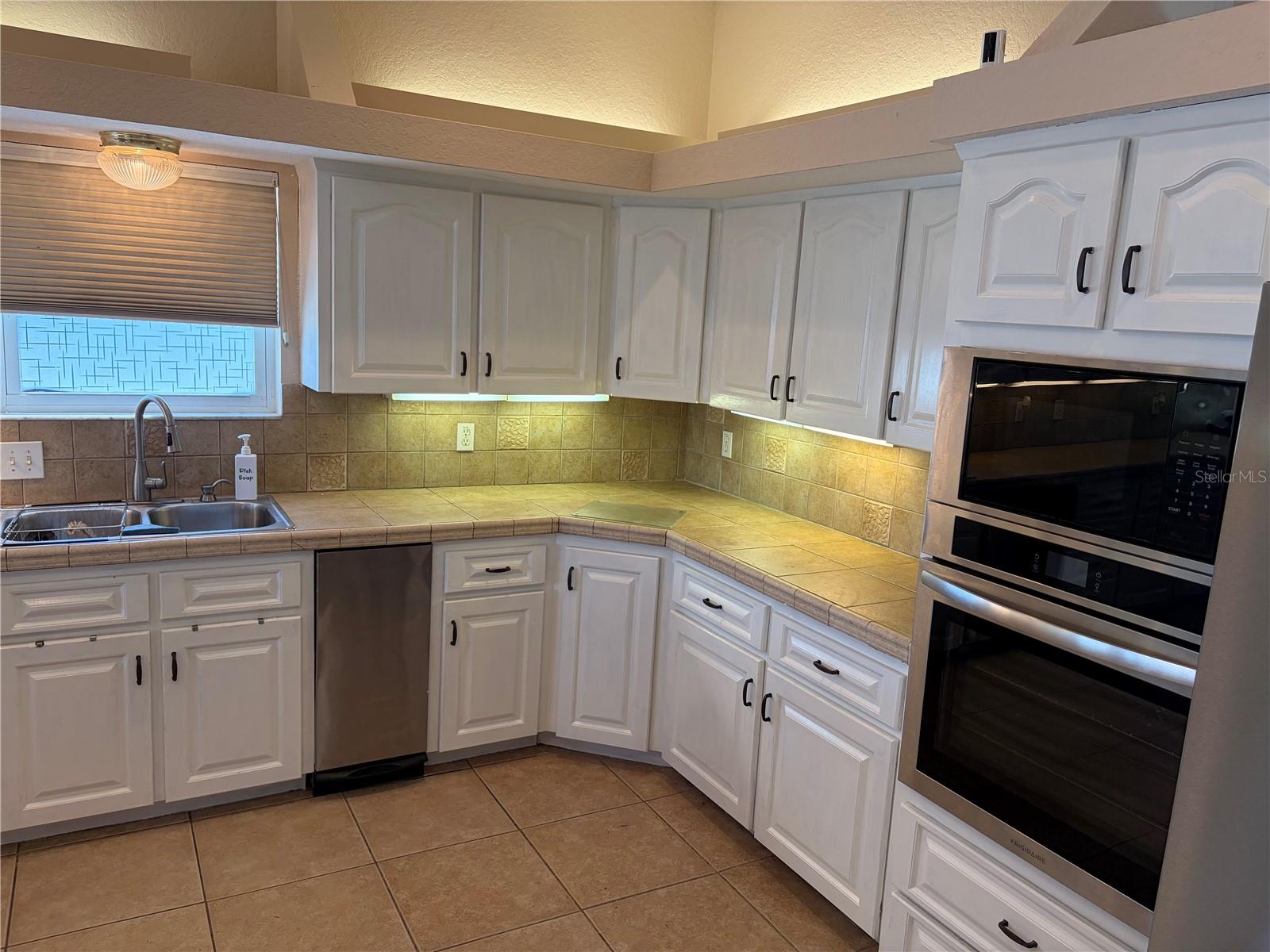 kitchen with new trash compactor, oven and microwave