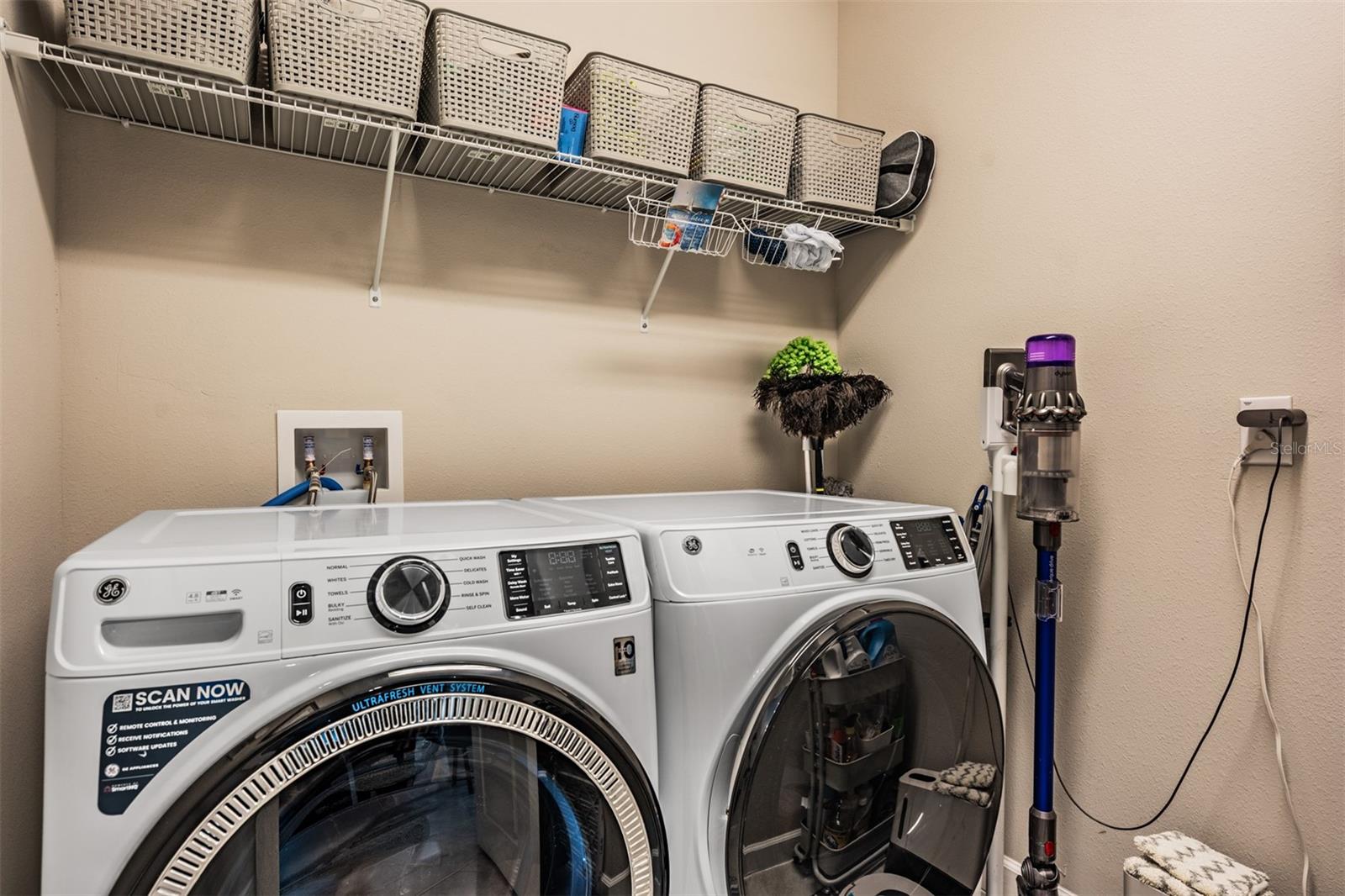 Interior laundry room with storage above