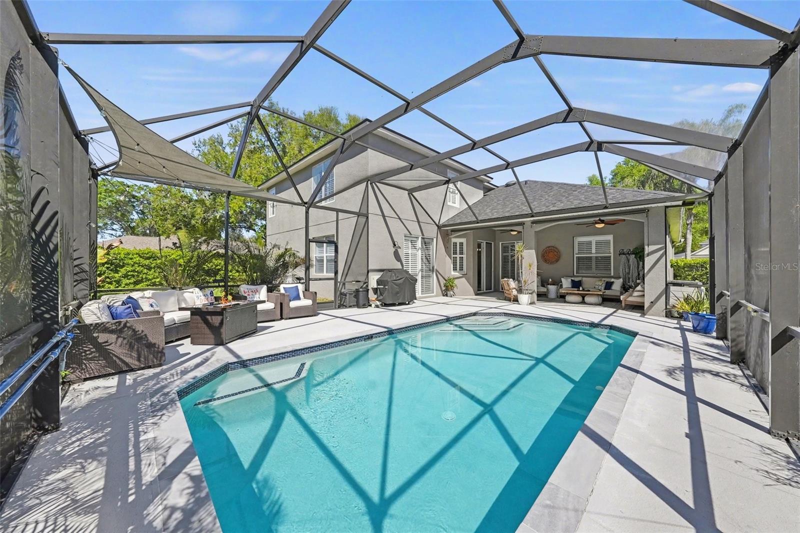 The tall screen enclosure allows you to enjoy this incredible outdoor space without feeling confined. There's room for a crowd out here - whether you're splashing in the pool, grilling out, relaxing in the sun, or chilling under the fans in the covered lanai, this home has got you covered.