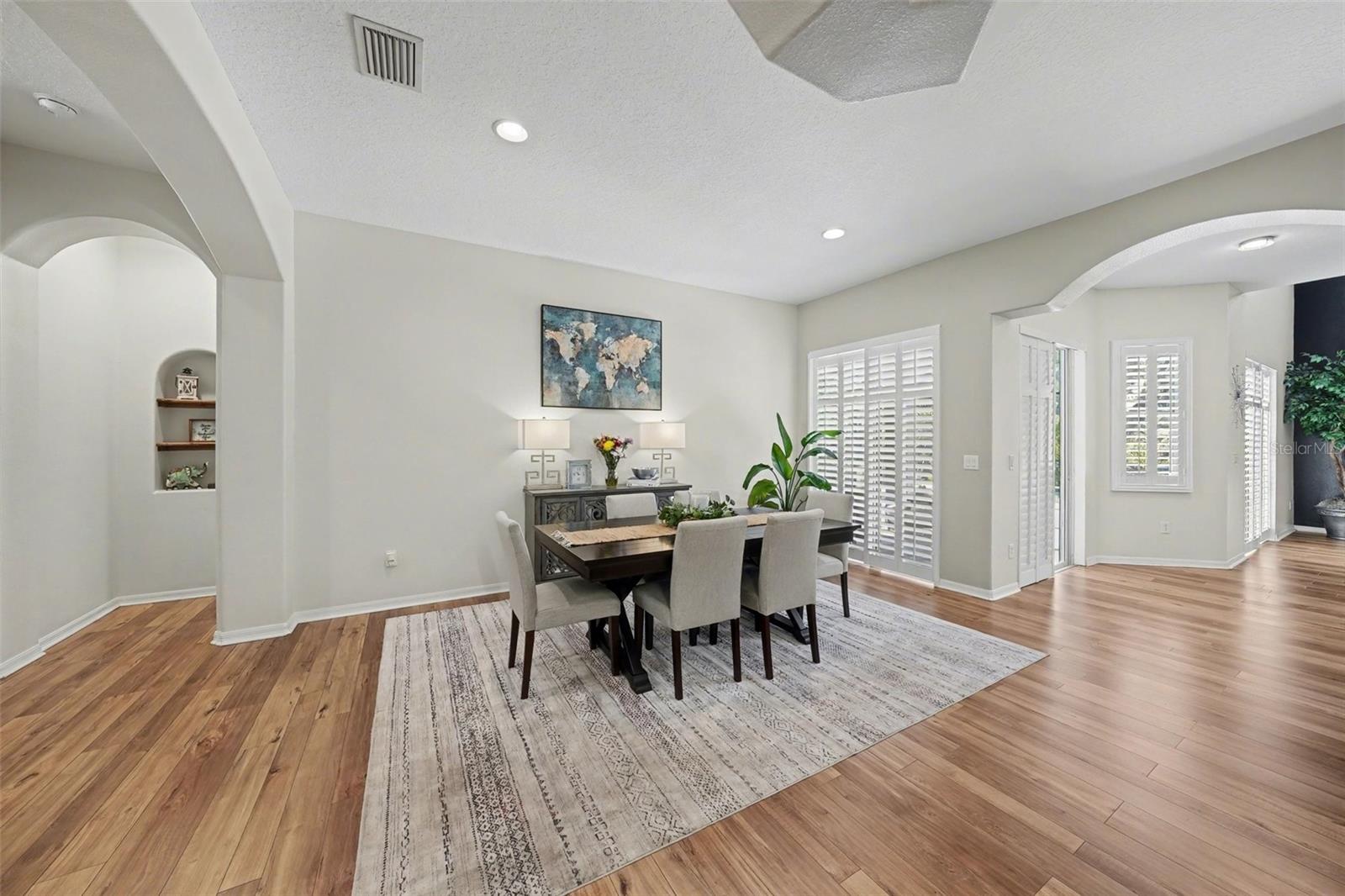 Open and airy with arched doorways, recessed lighting, and plantation shutters throughout.