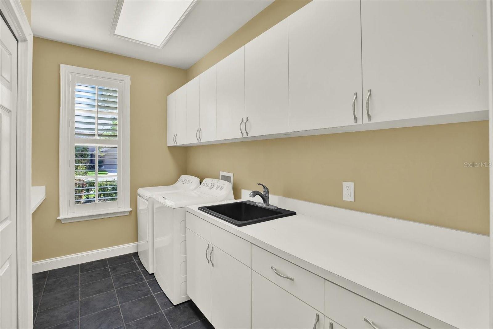 The laundry room includes plenty of counter and storage space.