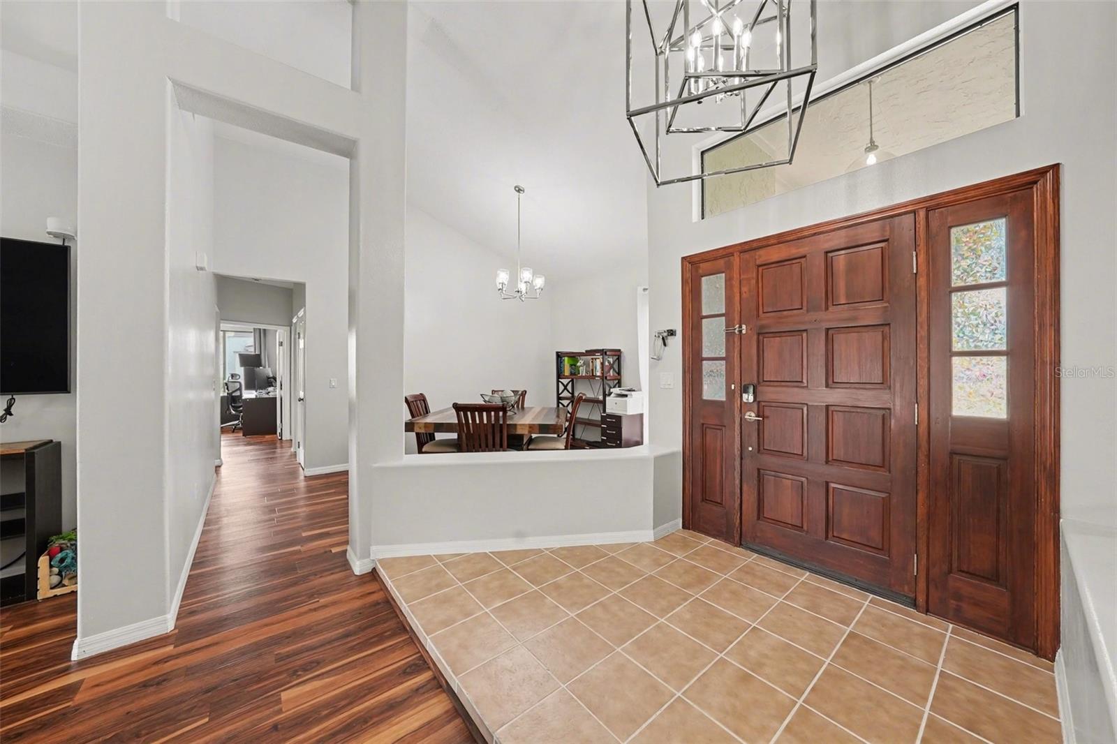 The grand entrance features a gorgeous modern light fixture that is just perfect for that space
