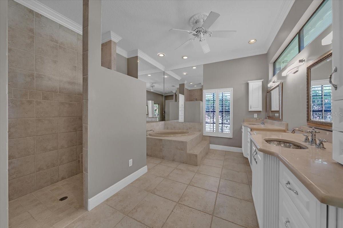 Spa-inspired primary bath with oversized tiled shower and garden tub