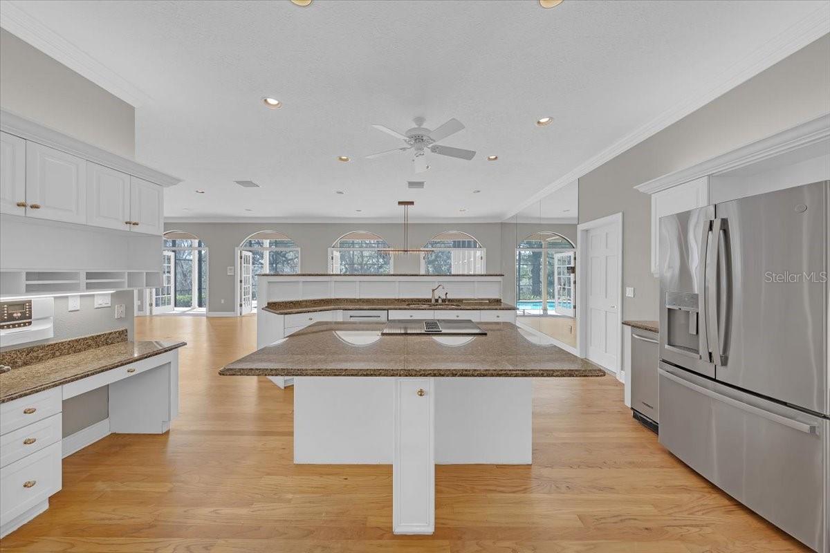 Bright open kitchen with expansive island and stainless appliances.