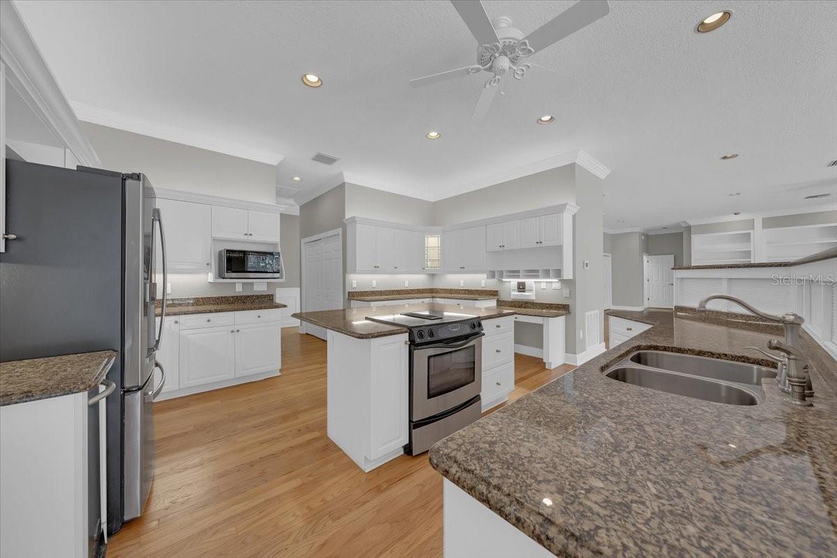 Abundant cabinetry, center island, and warm wood floors.