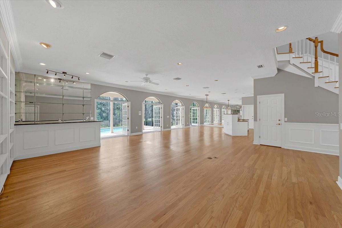 Great room floor plan with hardwood floors accented by a wall of French doors.