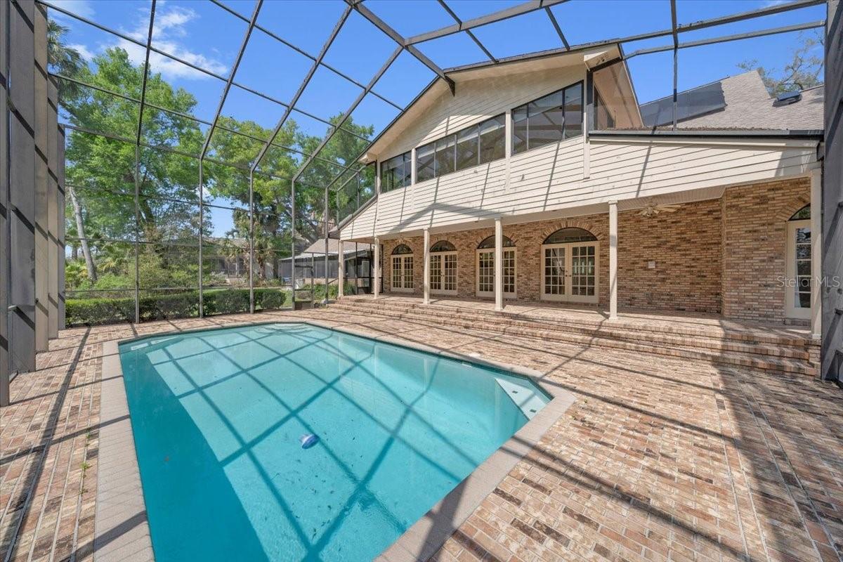 2 story cage sits over a spacious pavered lanai.