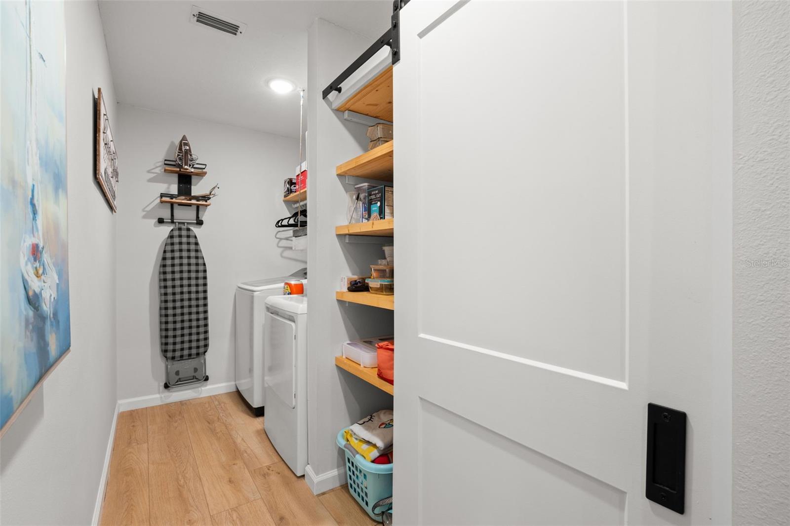 barn doors hold pantry area on one side and storage on the other