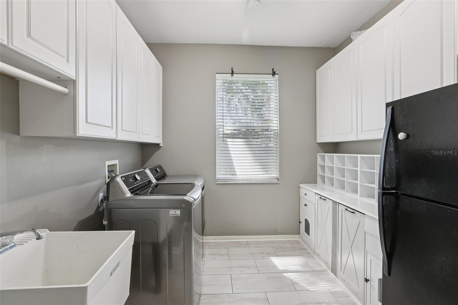 Laundry room with built in shelves and an extra refrigerator