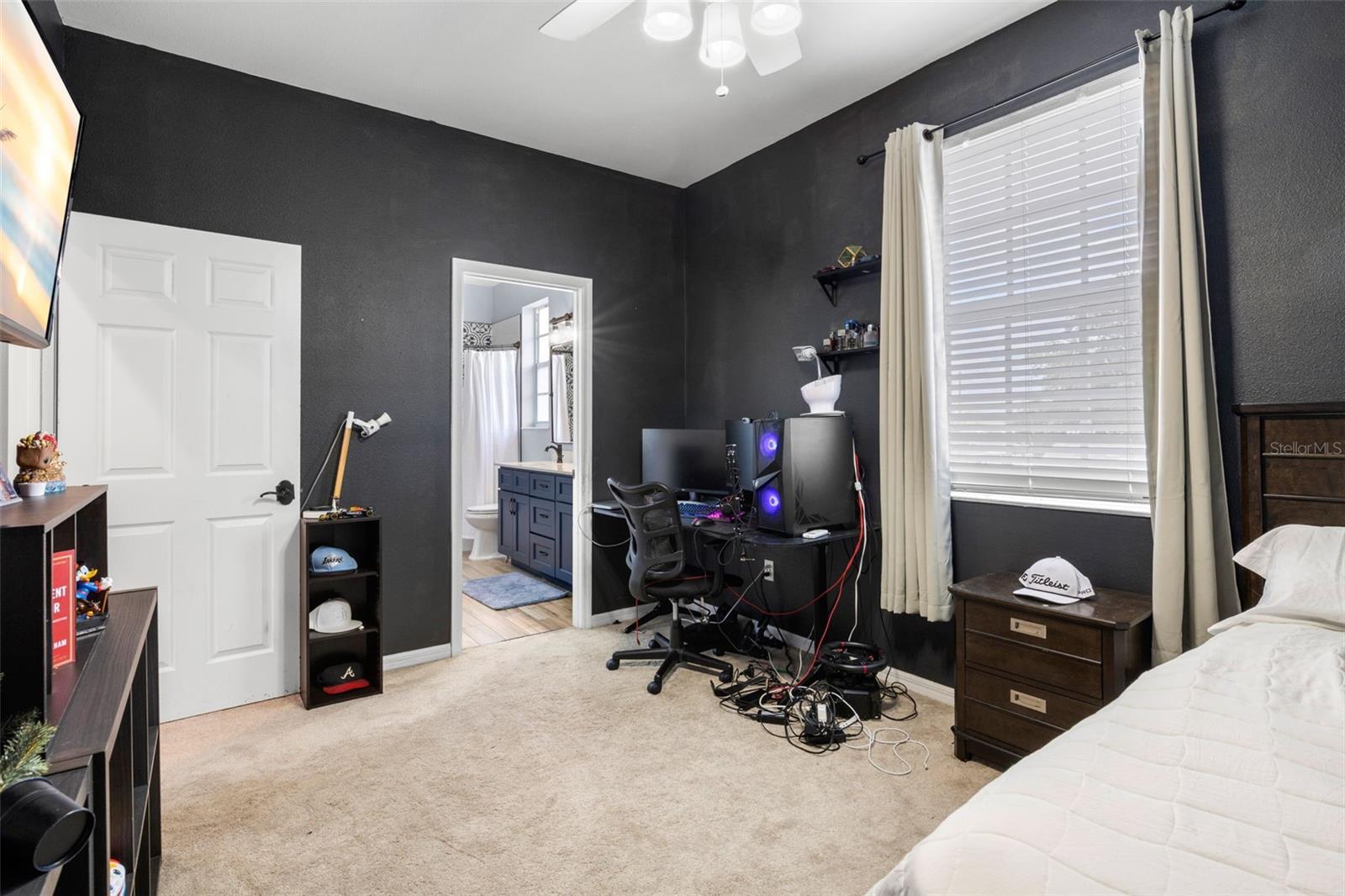 Bedroom 3 featuring plush carpeting, a window for natural light, built-in closet, and convenient access to a shared Jack and Jill bathroom.