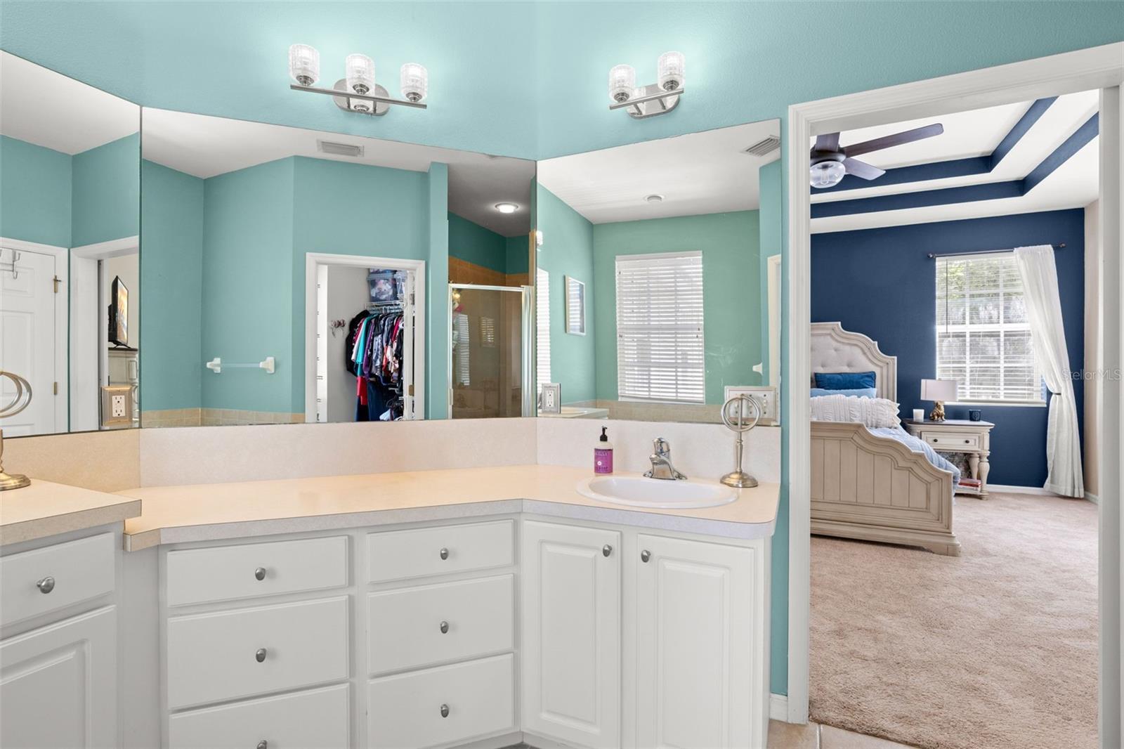 Well-designed primary ensuite with an extended dual-sink vanity, ample storage, and a large mirror, connecting effortlessly to the walk-in closet and primary bedroom.