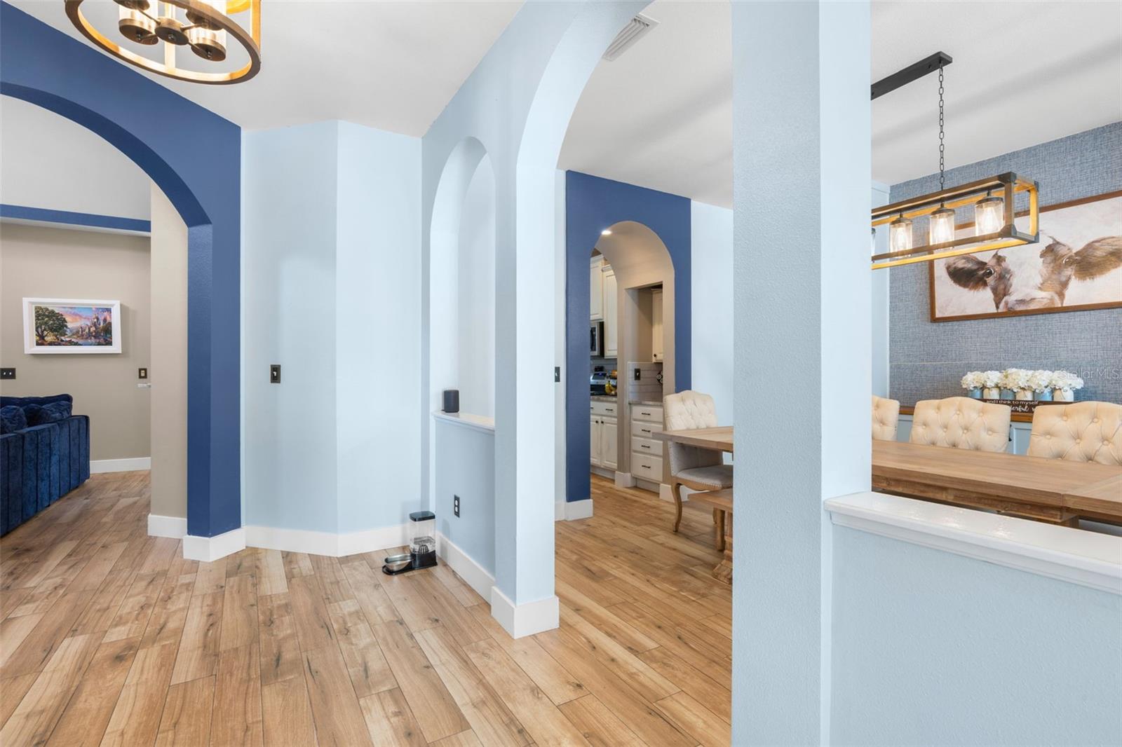 Entryway features wood plank tile flooring and graceful curved archways.