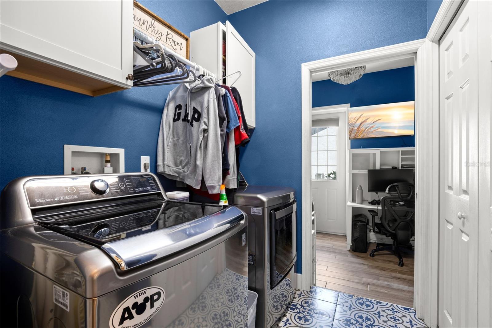 The laundry room includes washer/dryer hookups, mosaic tile flooring, built-in cabinetry, and additional storage.