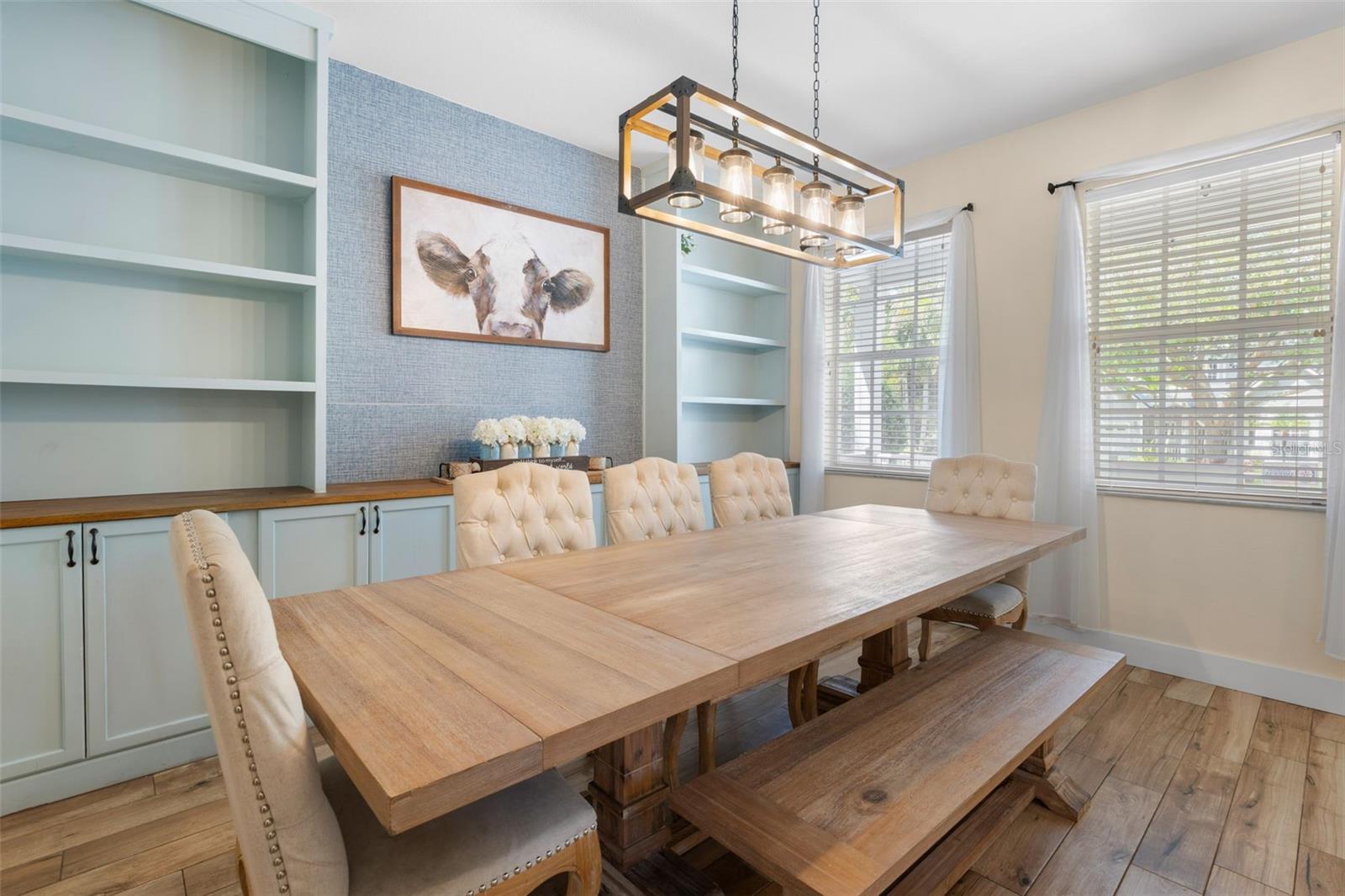 The dining room makes a statement with an Edison-style chandelier and custom wood shelving and cabinetry.