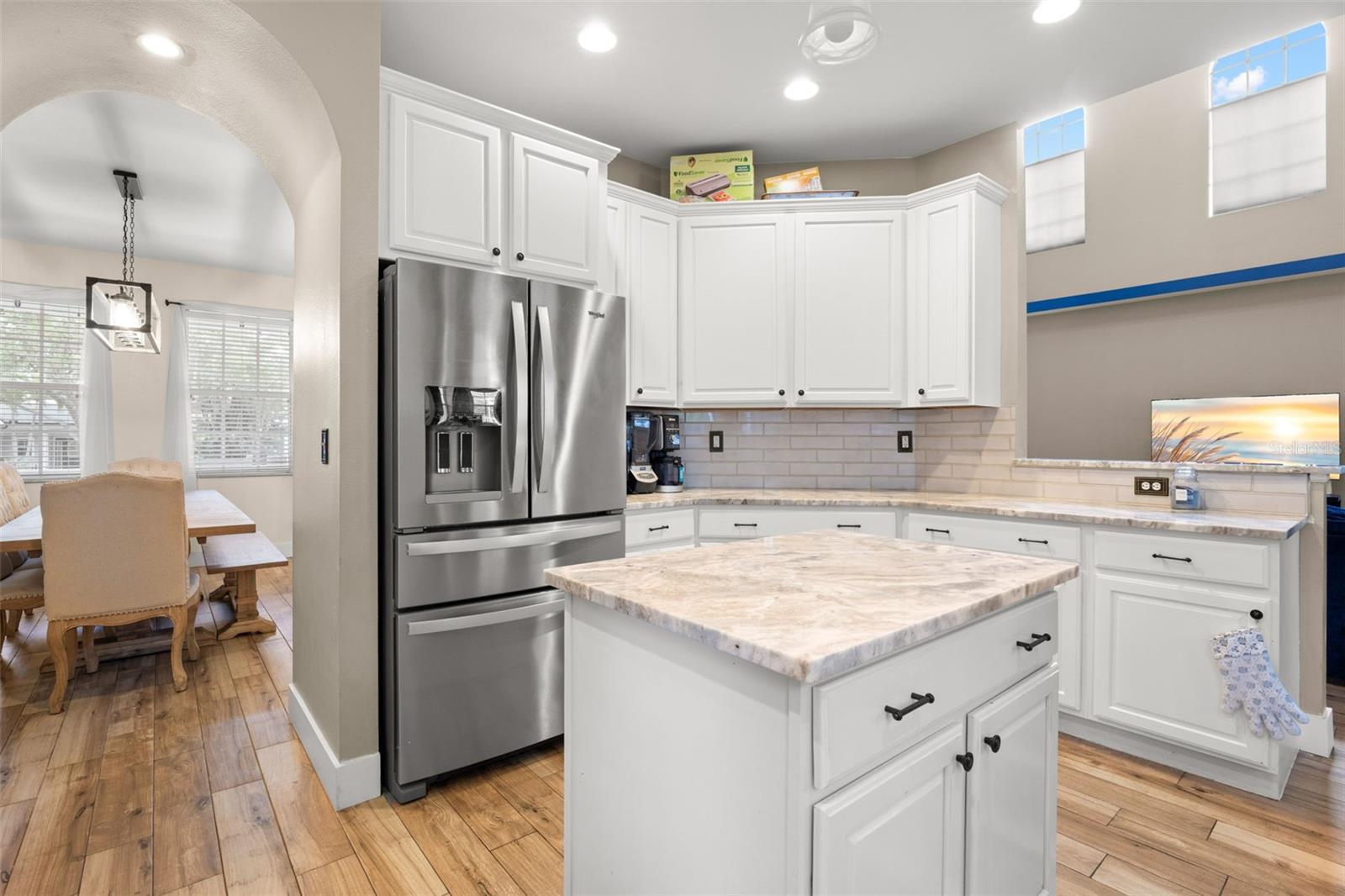 The kitchen is open to the dining room through an arched passage