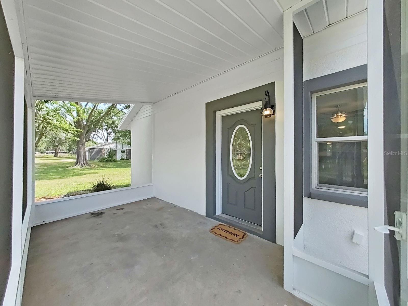 inside front porch looking north you can see the separate garage and pond is beyond that.