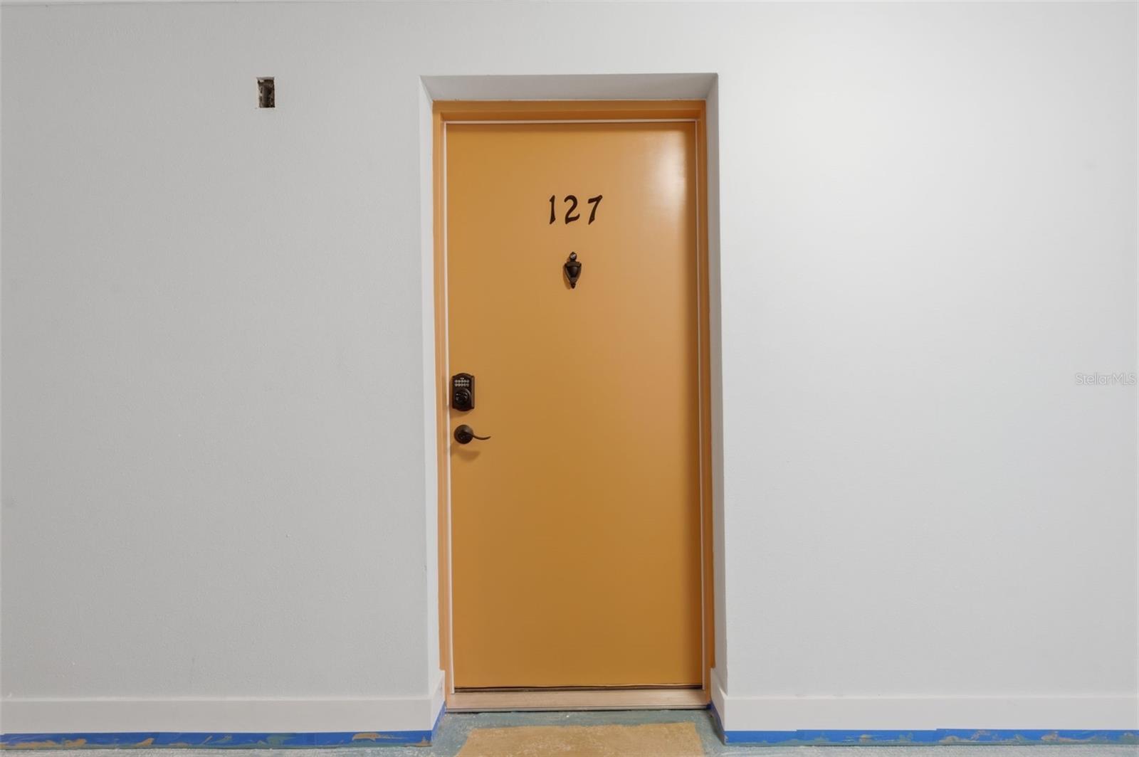 Unit 127, First door inside the hallway on the right.