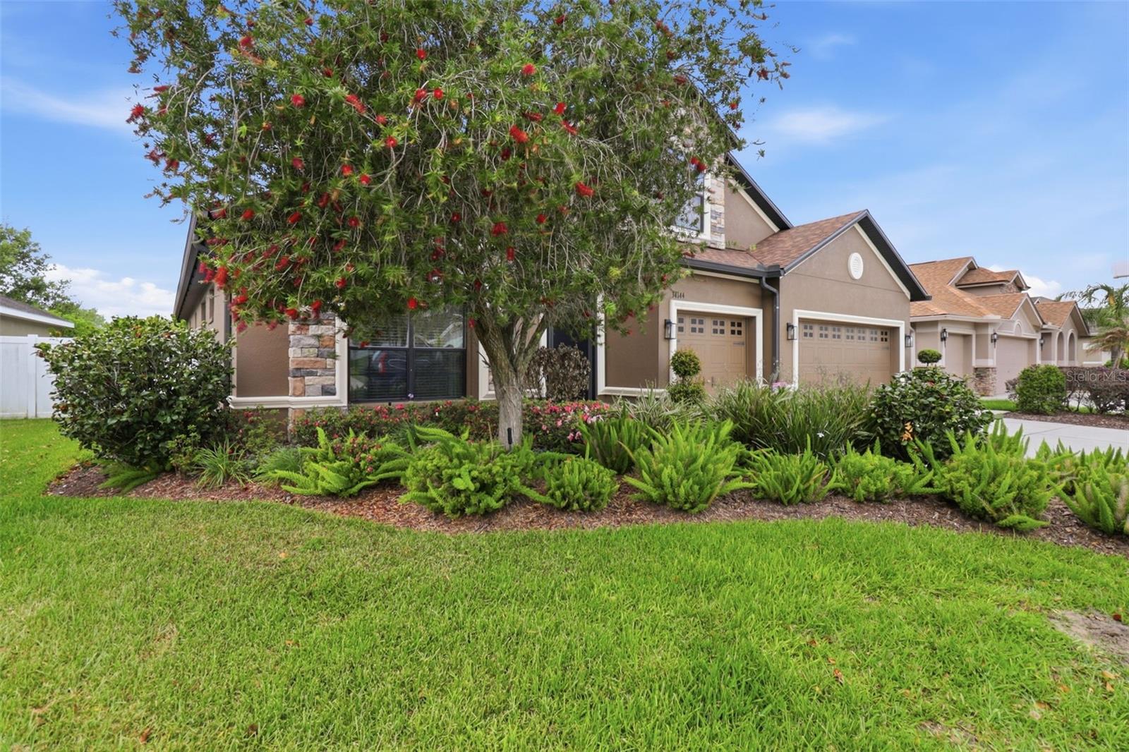 Additional exterior view highlighting mature landscaping, inviting curb appeal, and the home’s well-maintained front yard.