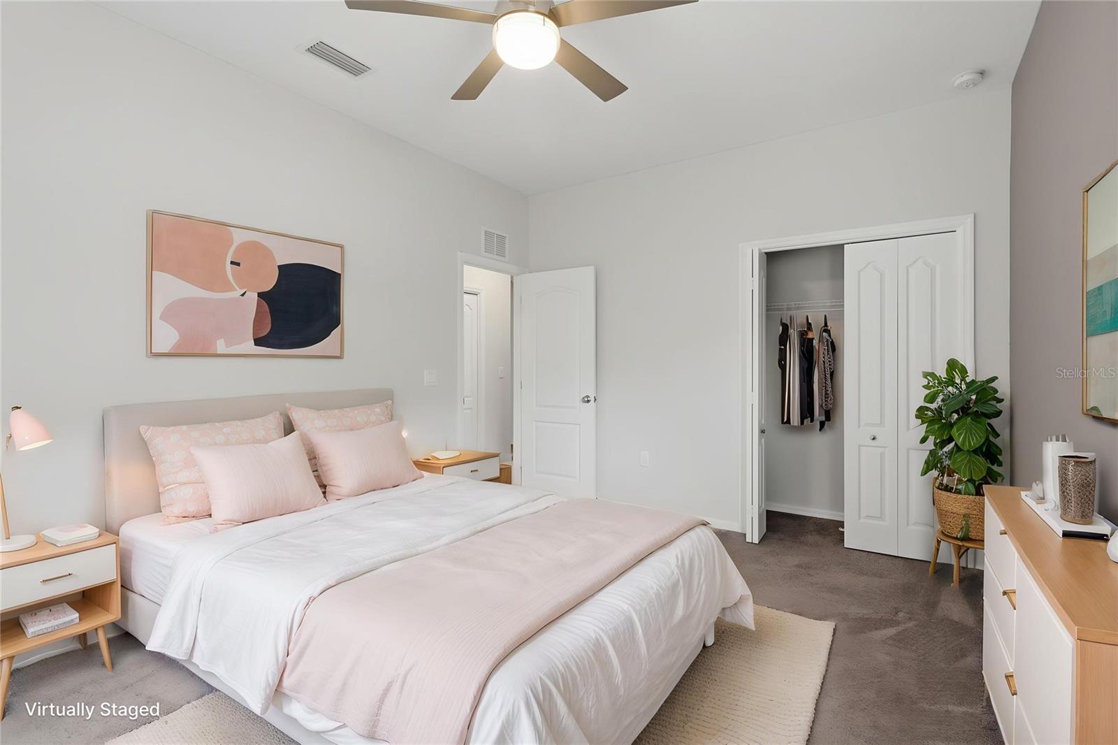 Spacious secondary bedroom with natural light, neutral finishes, and ample closet space.