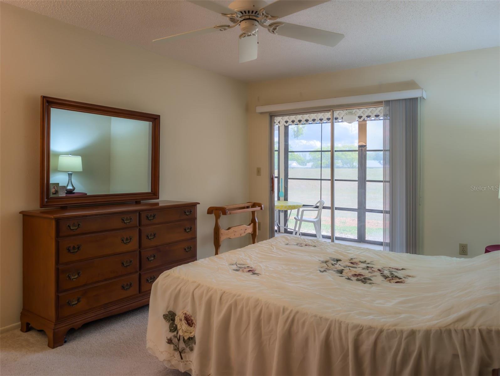 Master bedroom has sliding doors to the porch and views of nature