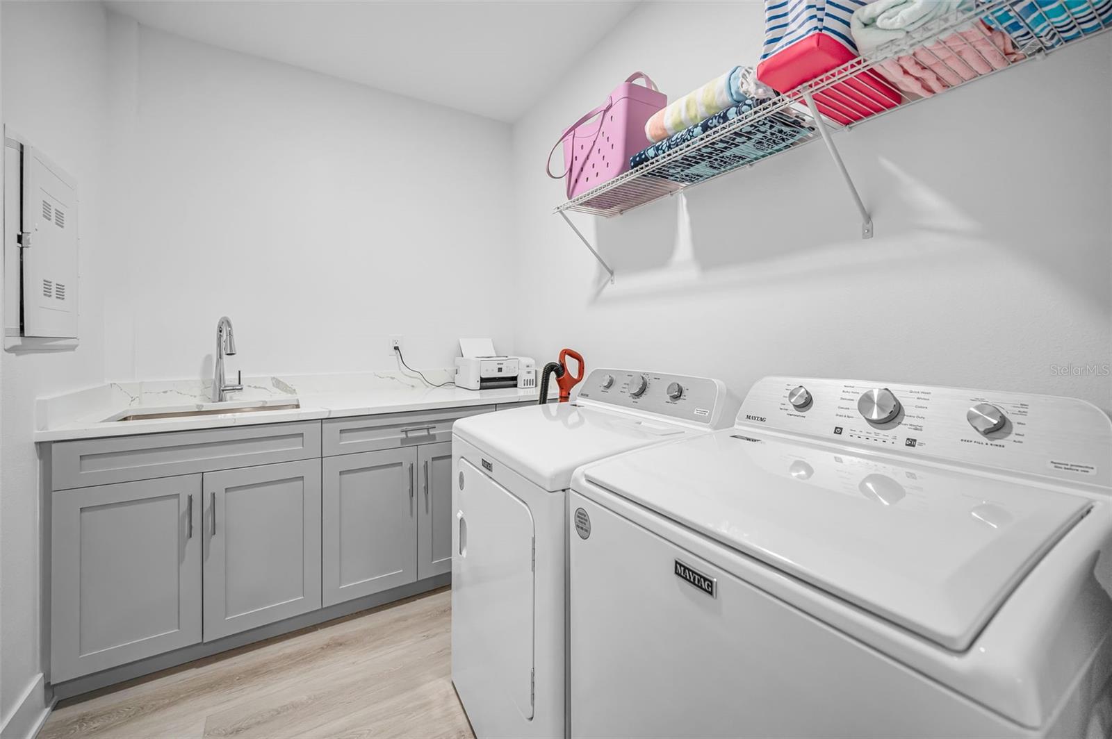 Large Utility Room with Countertop and Sink along with full sized washer and dryer