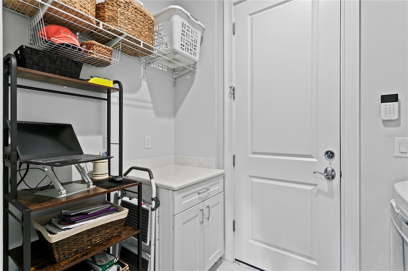 Opposit view of laundry area showing off storage and a convenient area for a work space.