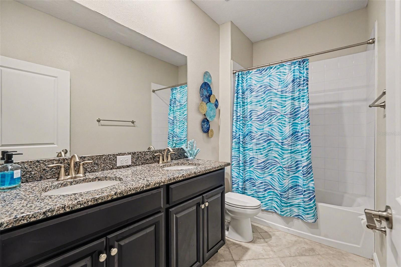 2nd Bath features granite counters, a double vanity and tub with shower.