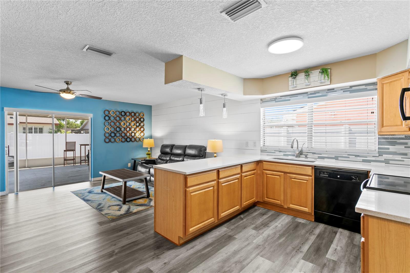 Kitchen opens to family room with glass sliders to covered rear patio