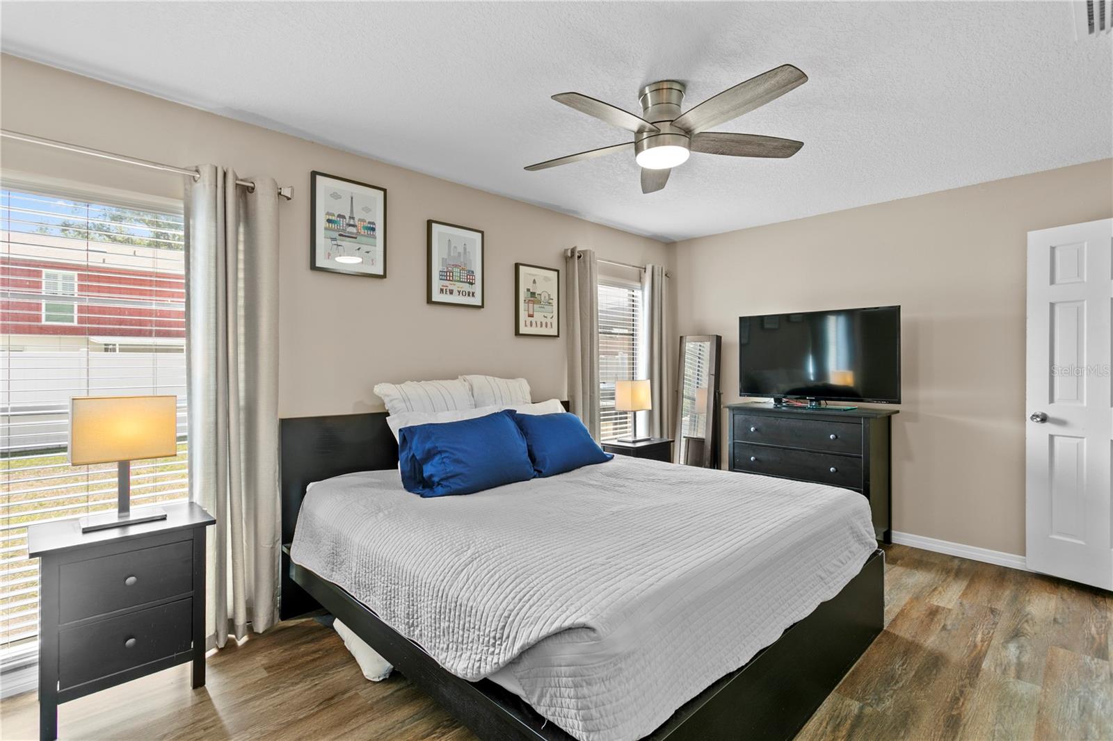 Primary bedroom features a ceiling fan and ensuite bath
