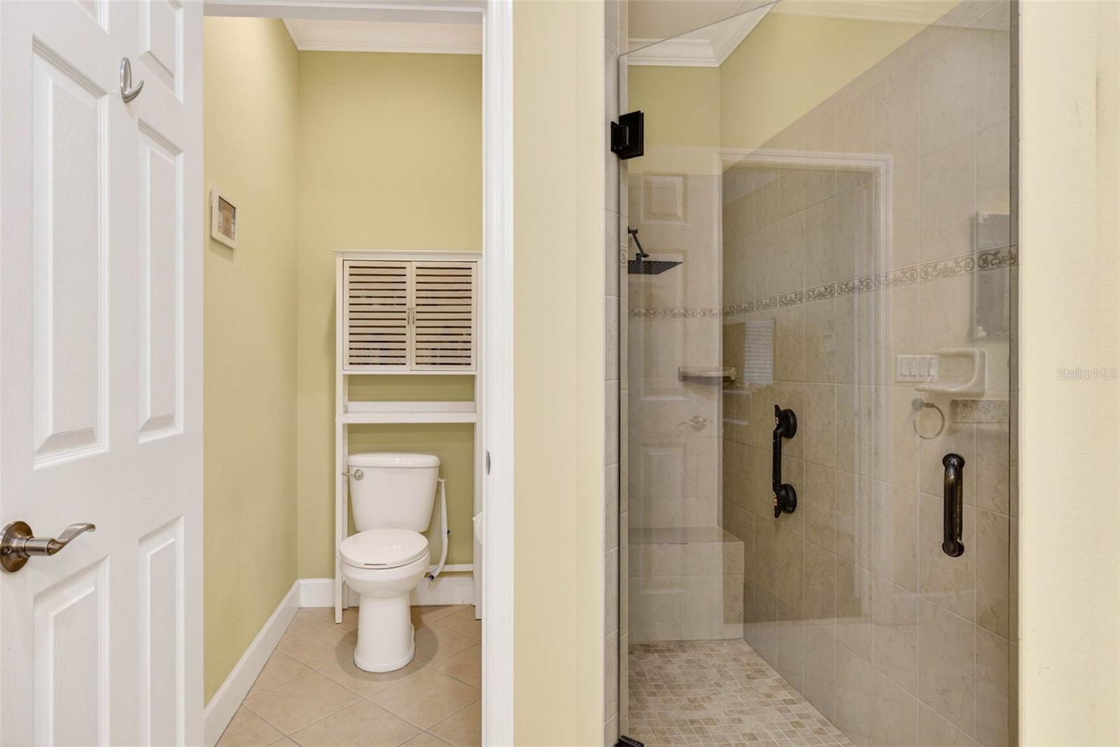 Private wash closet and walk in shower with rain shower head.
