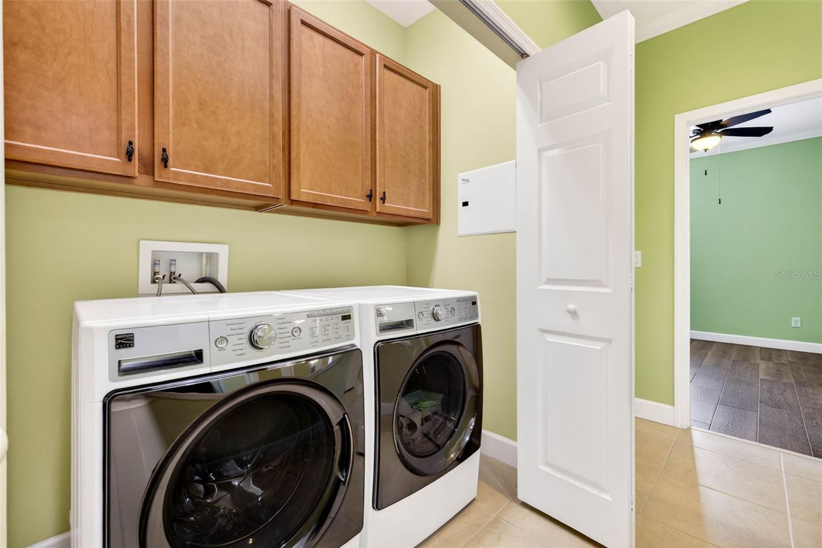 Laundry closet in hallway with cabinets. Washer and dryer convey