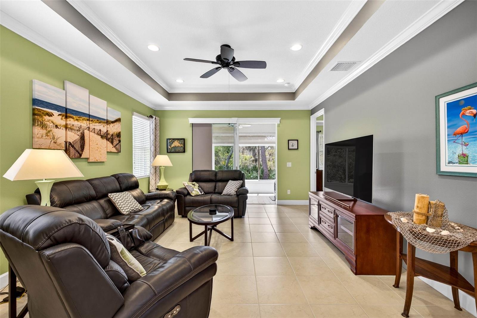 Living area with views of Little Manatee River Park through sliding glass doors. Tile throughout. Crown molding throughout.