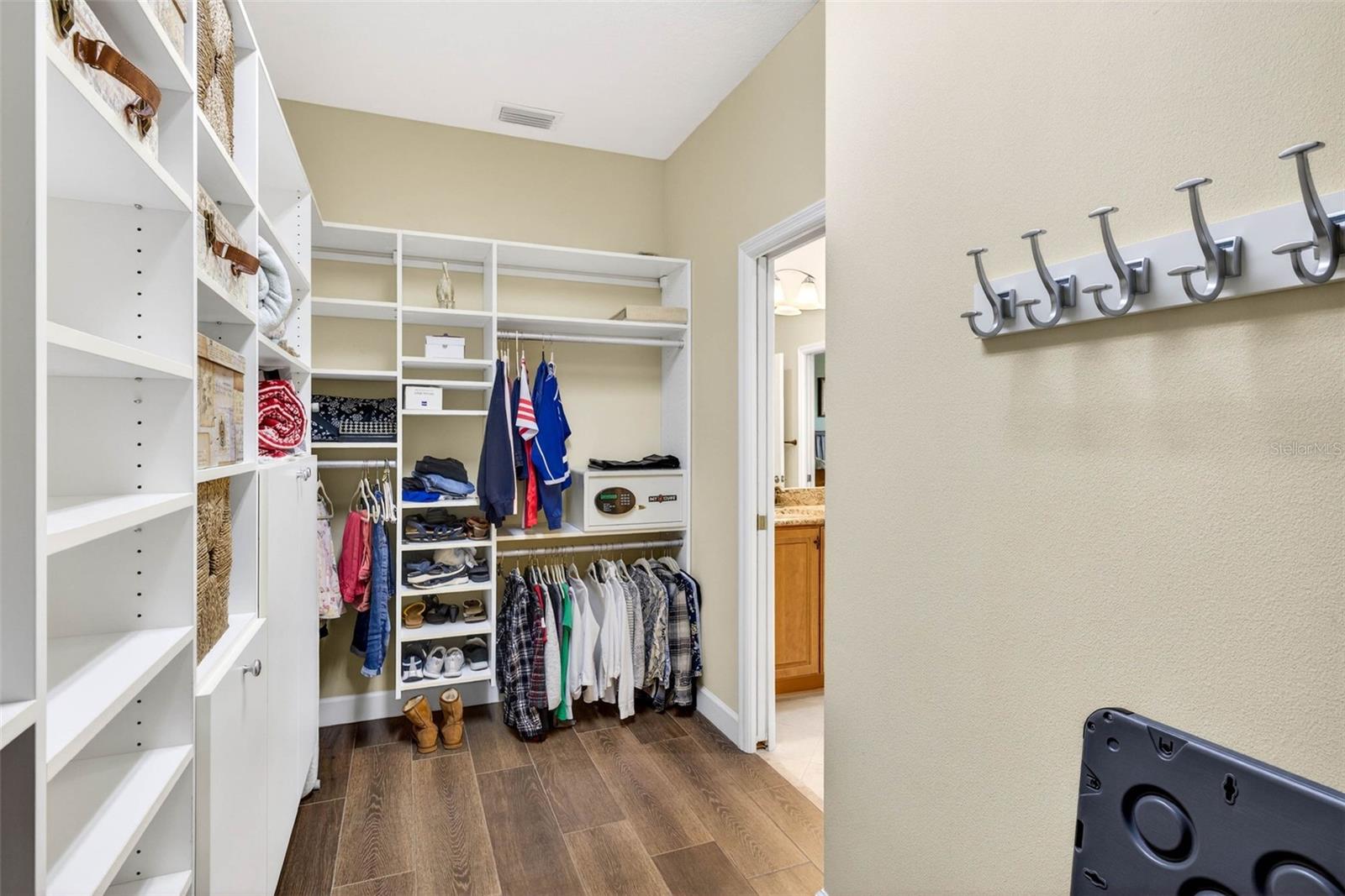 Primary closet with built in shelves and cabinets