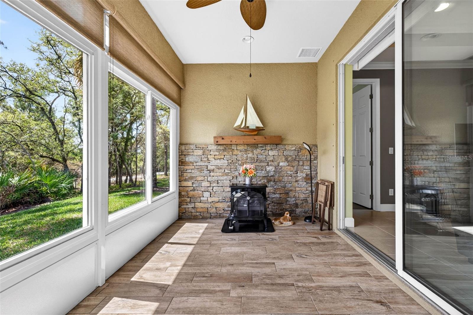 Decorative wall in air conditioned sunroom and sliding doors that lead to main living area and primary bedroom.