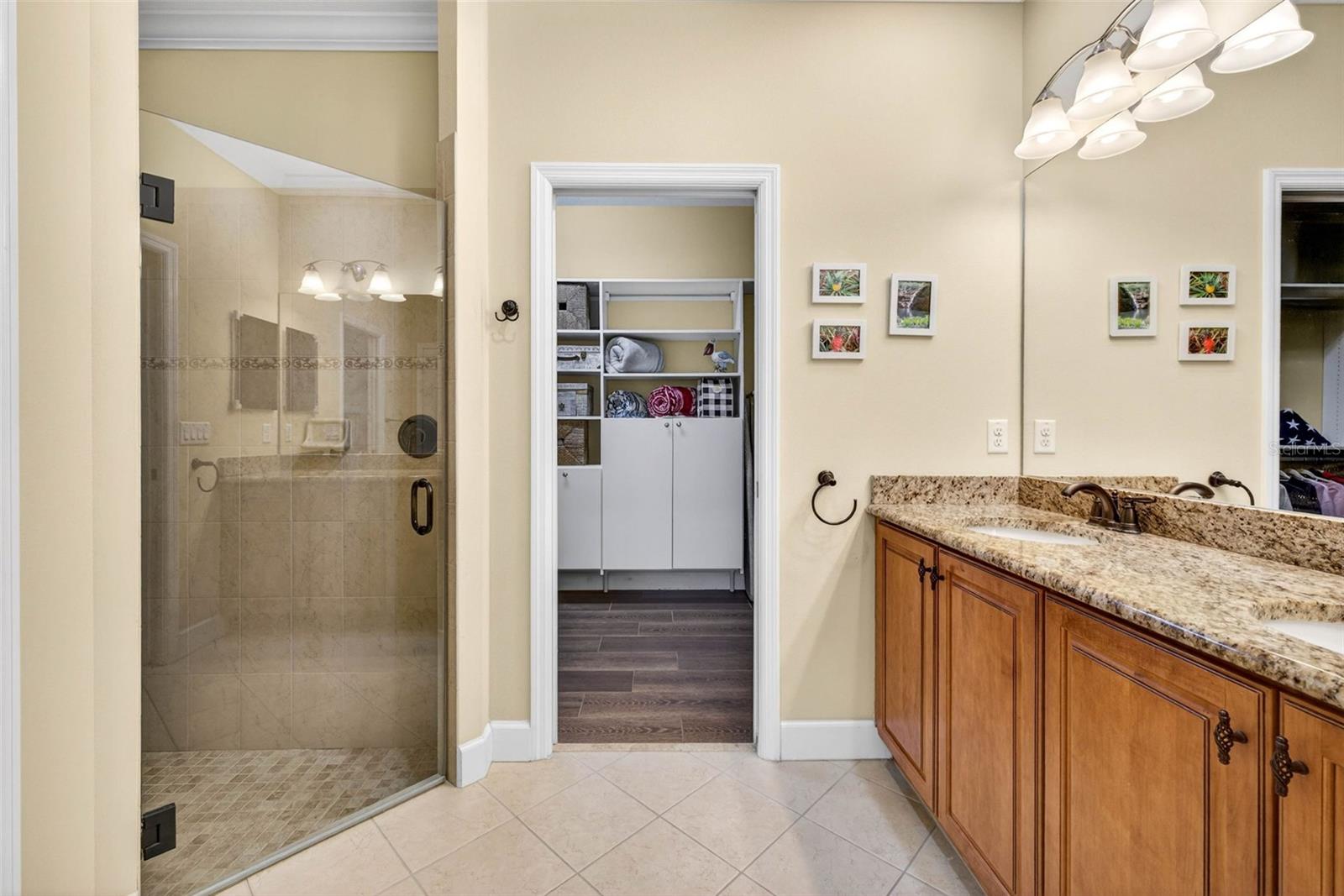 Primary bathroom with comfort height, dual sink vanity. Walk in frameless shower and large walk in, built out, closet.