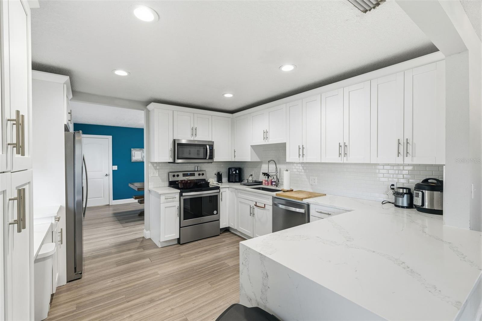 Updated kitchen with white cabinetry + bar seating