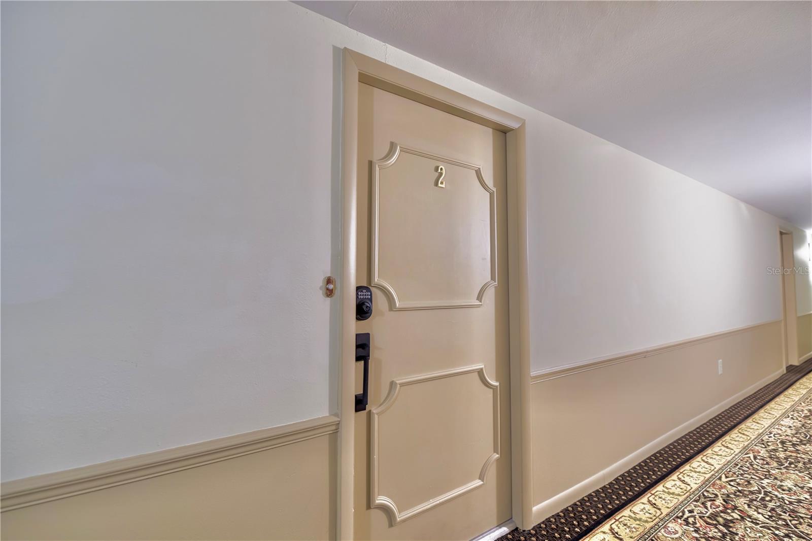 Front Door to Unit 1102 and interior hallway.  Trash shoot at the end of this photo not seen here.