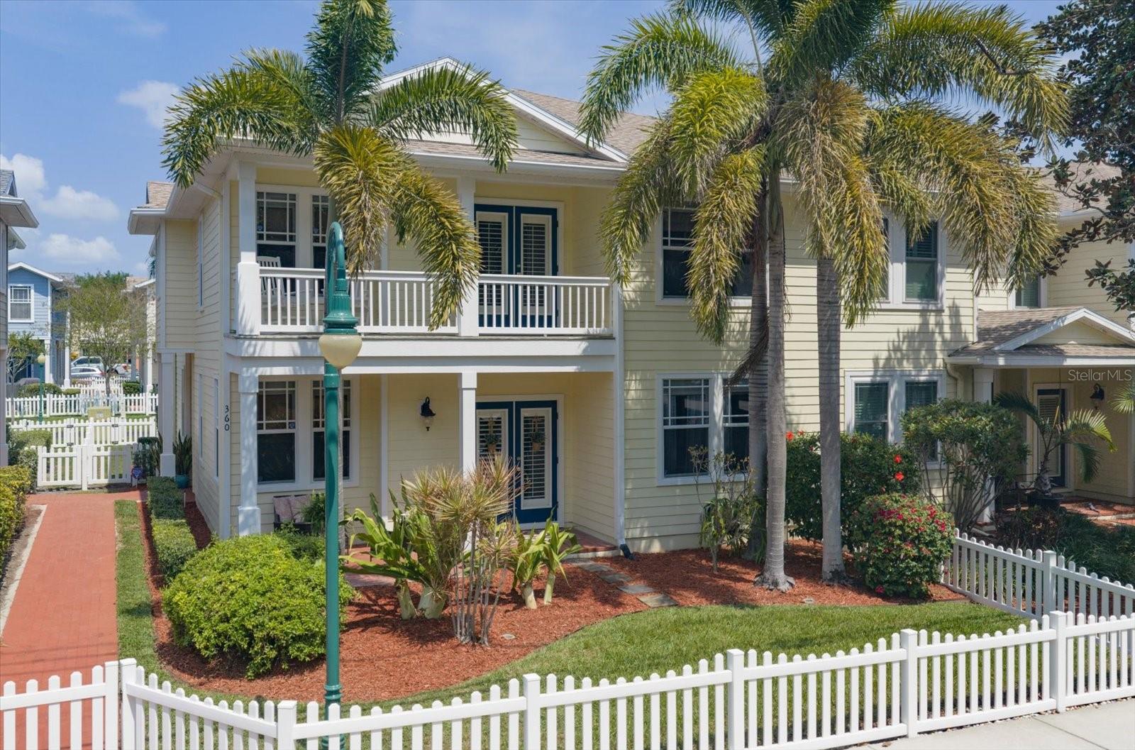 Front of unit, fenced front yard, large covered patio, brick walkway