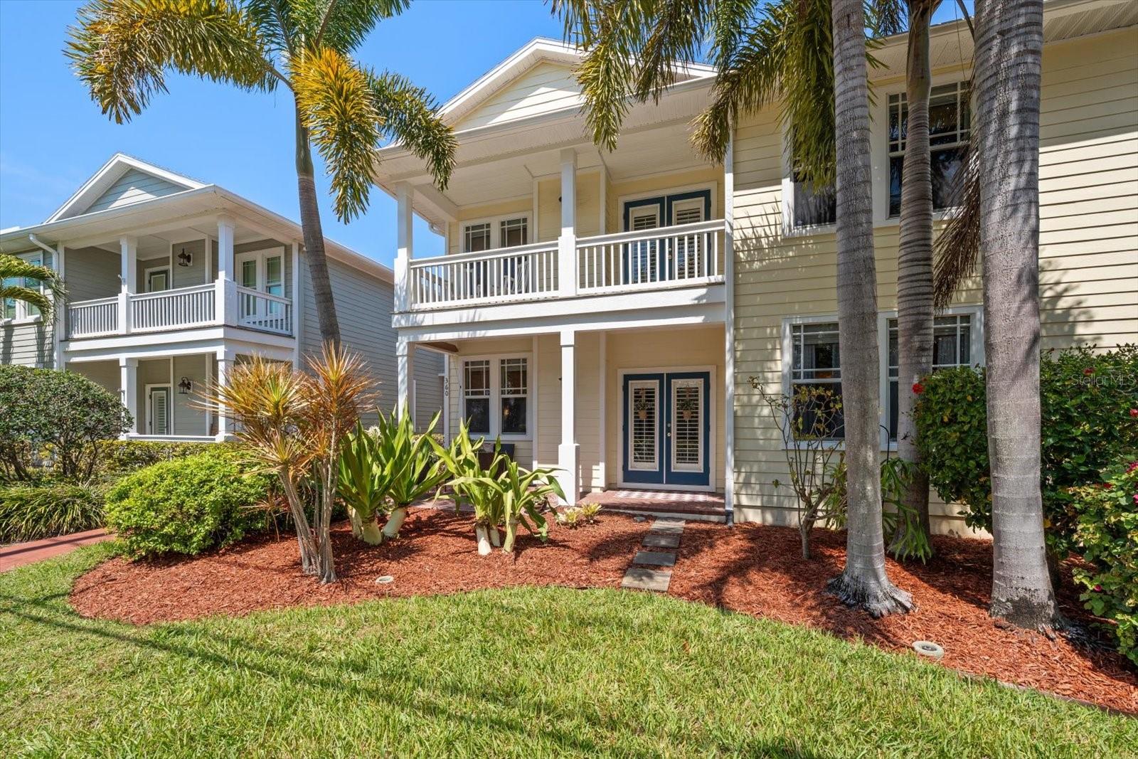 Front of unit, fenced front yard, large covered patio, french doors, palm trees