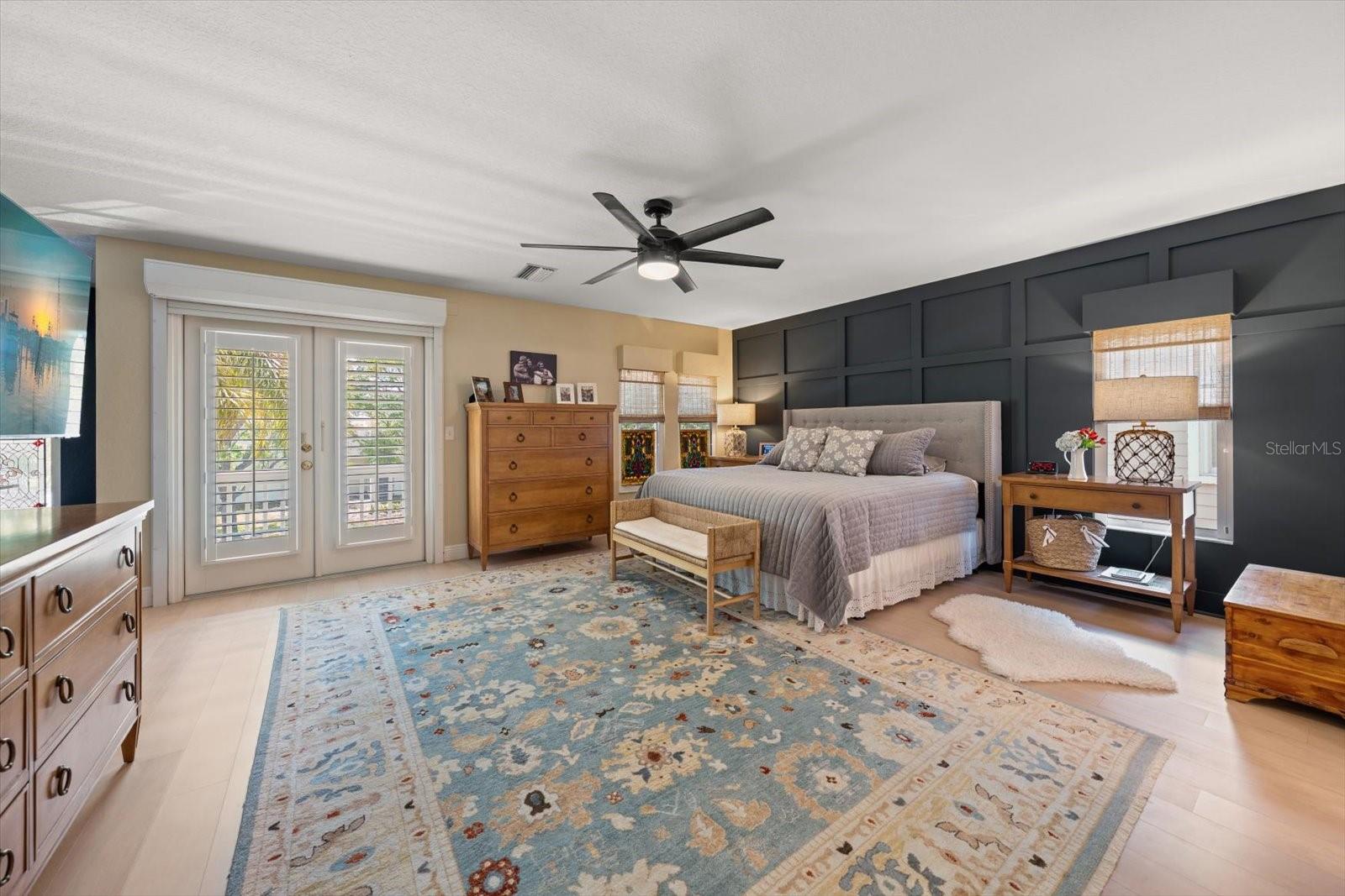 Primary suite with board & batten accent wall, French doors to balcony