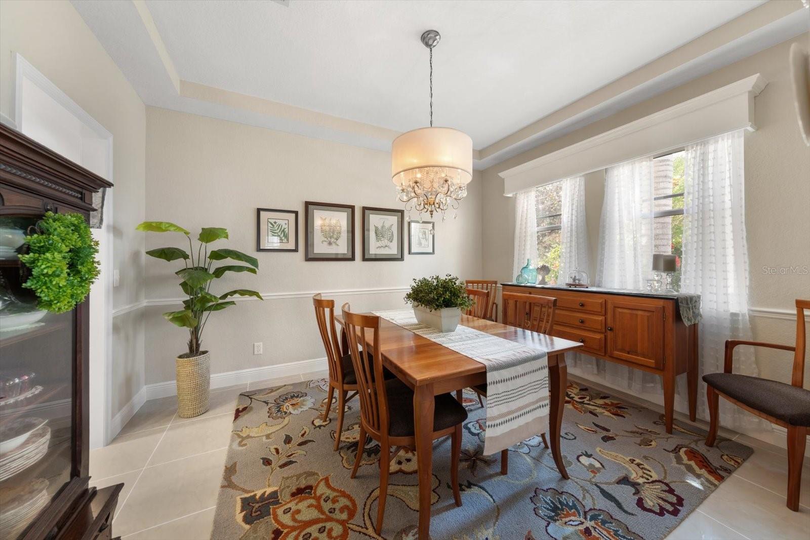 Dining room with chair rail and tray ceiling.