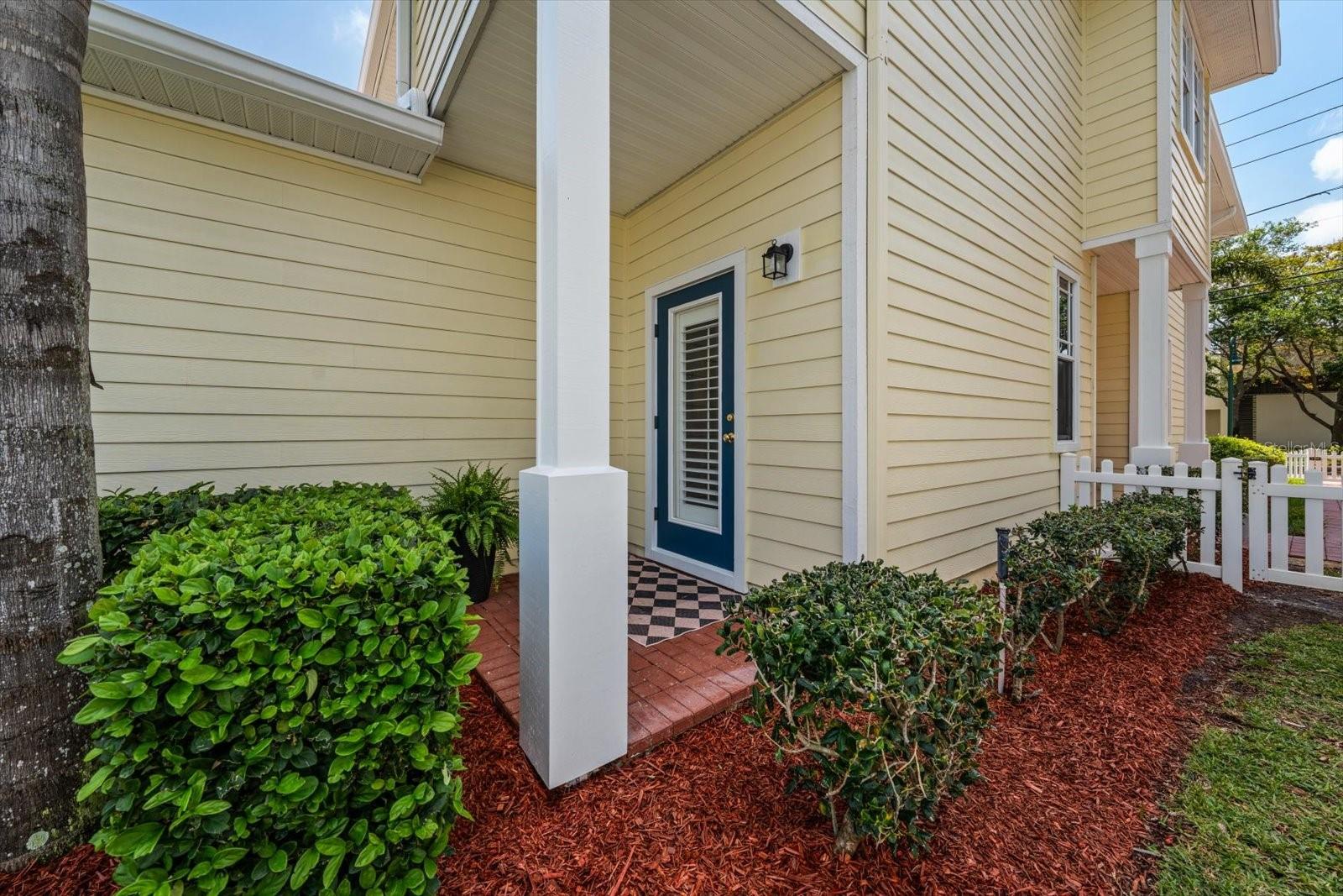 Covered brick patio in backyard with door to 4th bedroom/ flex space